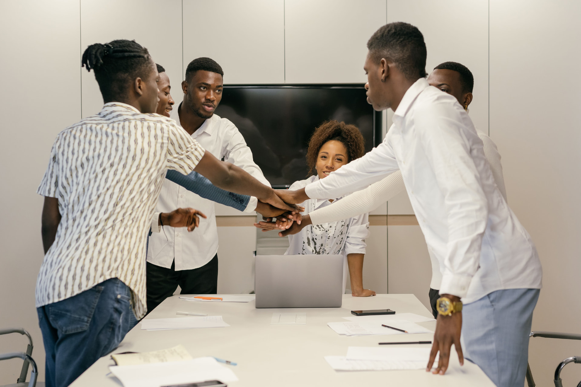 A team joining hands over a meeting table